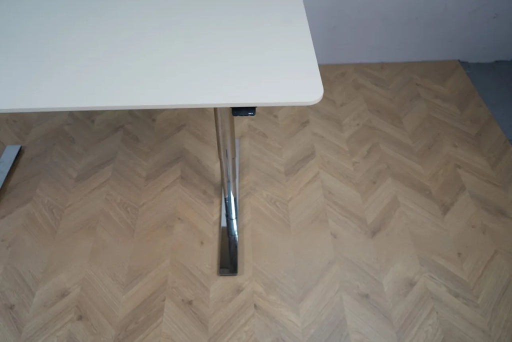 Minimalistisk dansk højdejusterbart bord i elfenbenshvid med runde hjørner og forkromet fod